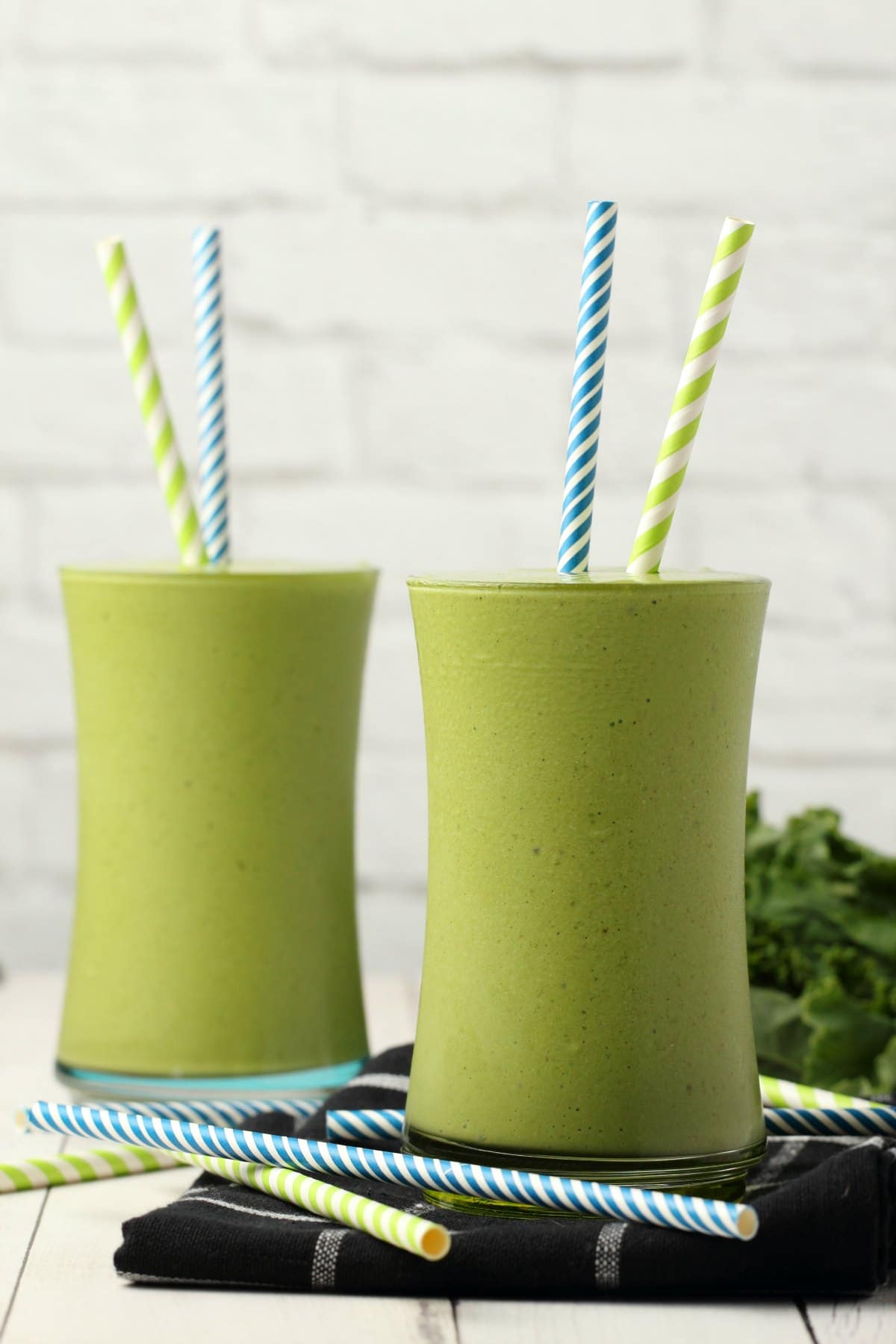 Kale Smoothie in glasses with striped straws. 