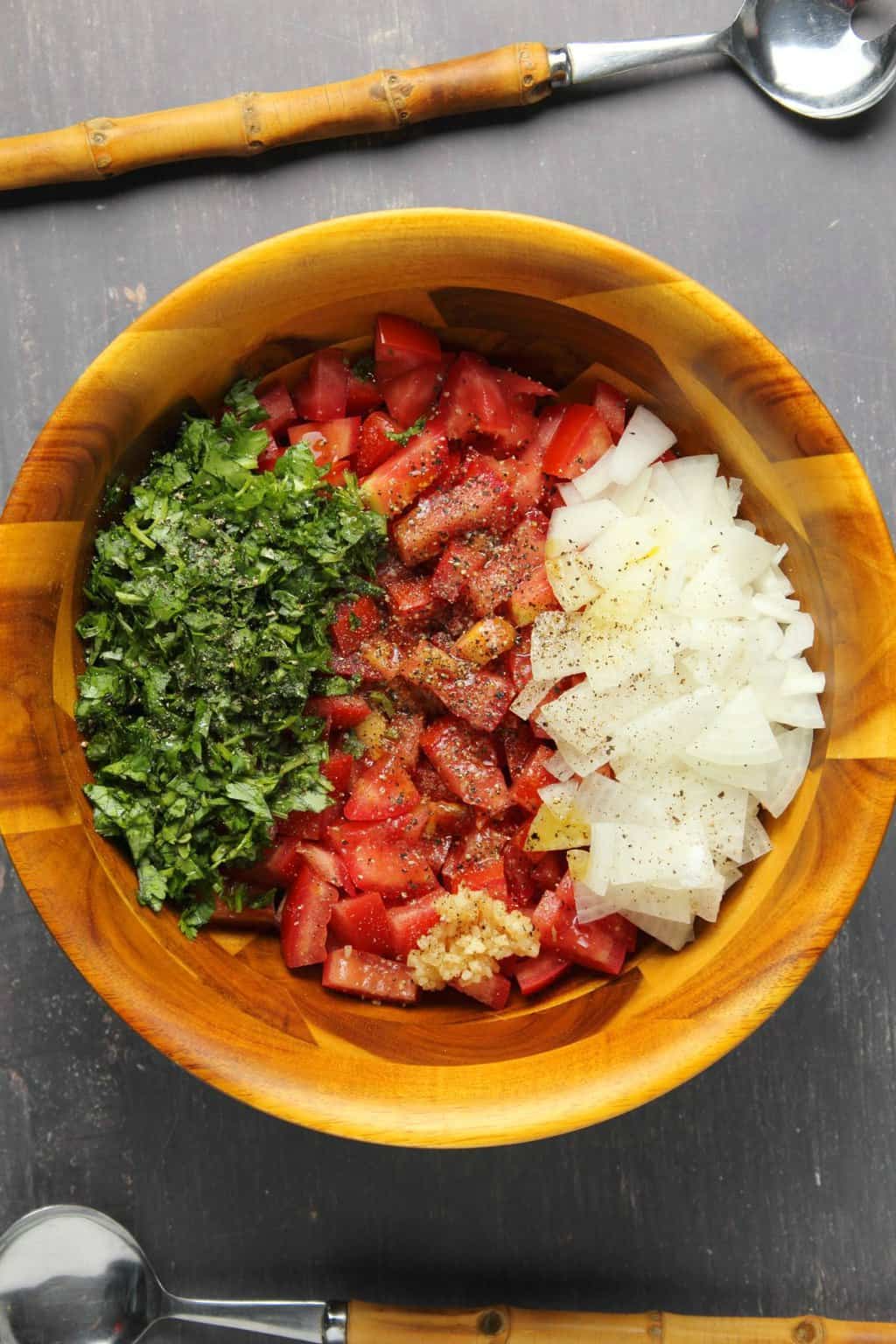 Ingredients for pico de gallo in a wooden bowl ready to be mixed up. 