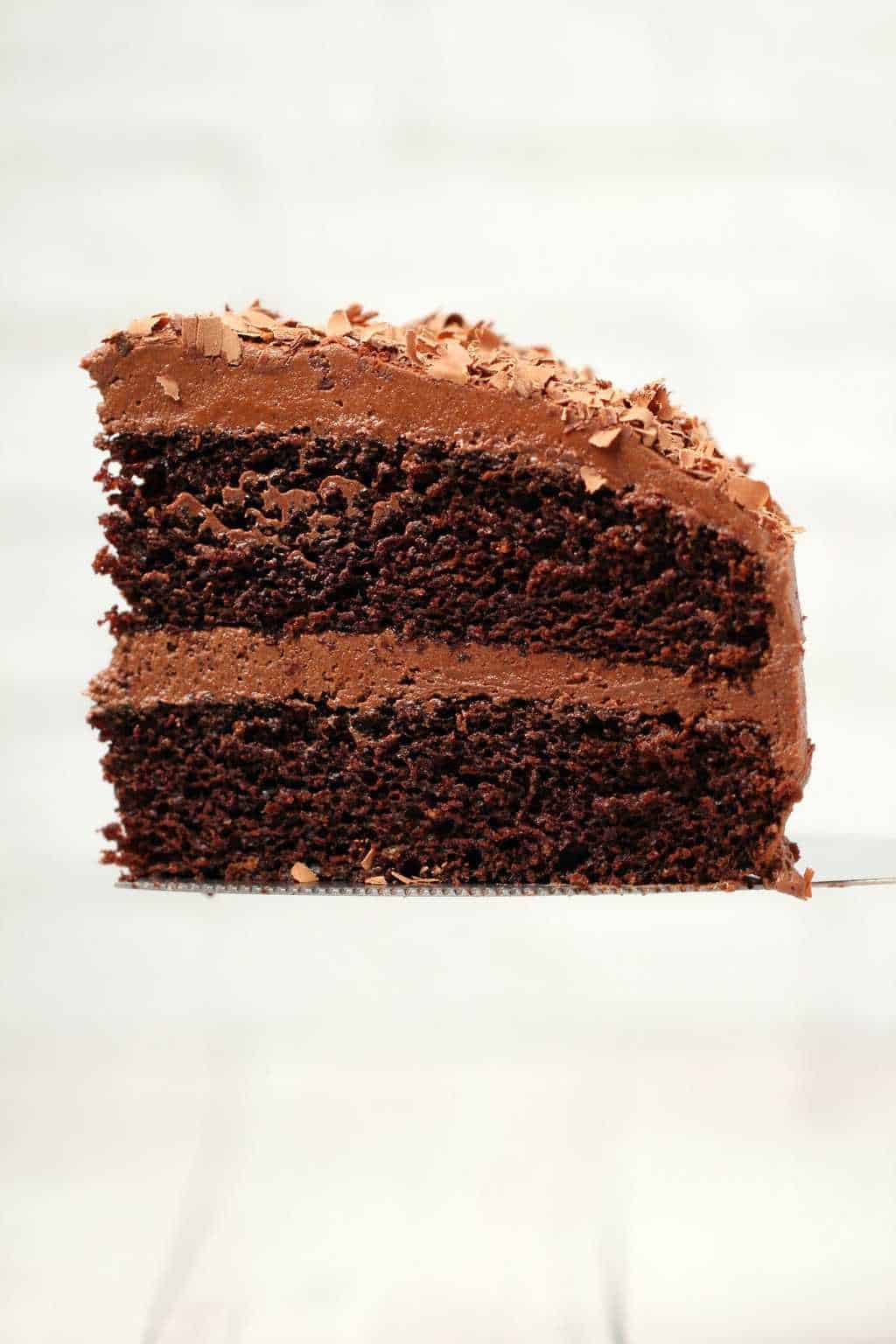 A slice of vegan chocolate cake on a cake lifter. 