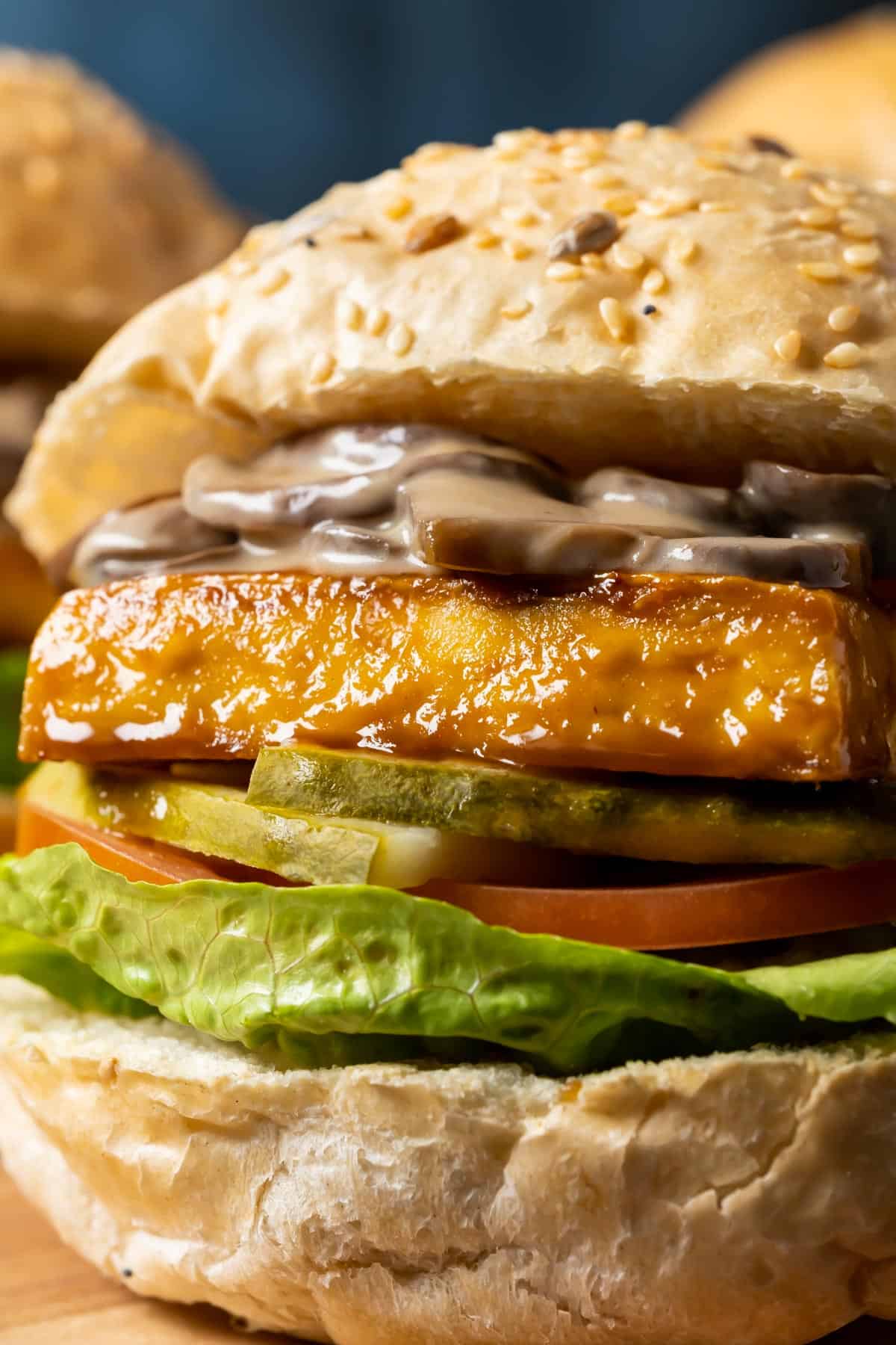 Close up photo of tofu burger topped with mushroom sauce.