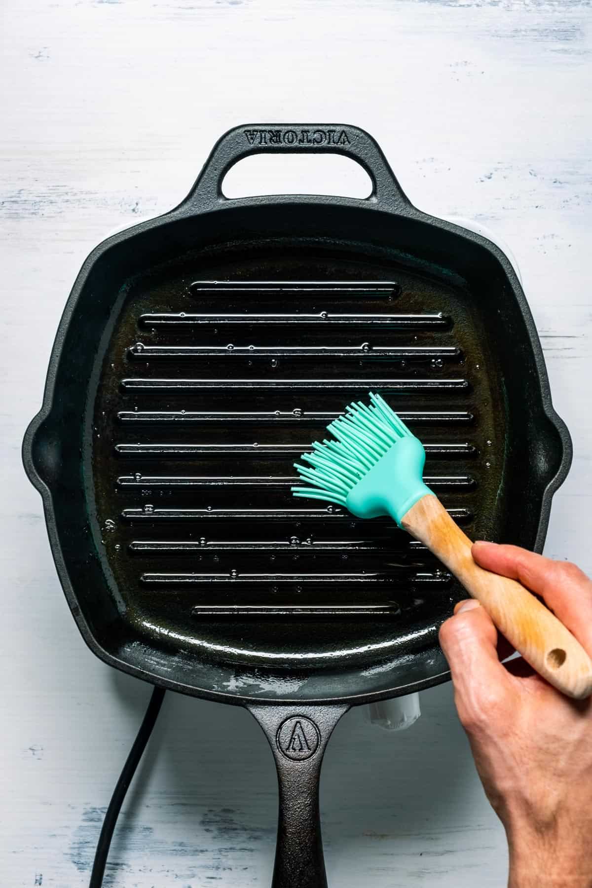 Photo of brushing oil onto a cast iron grill pan