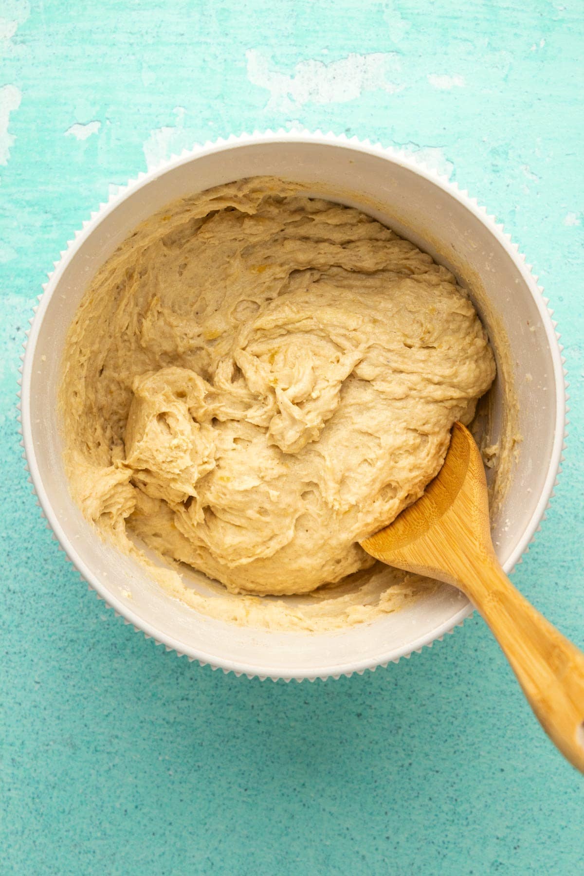 Batter for banana cookies in a mixing bowl with a wooden spoon. 