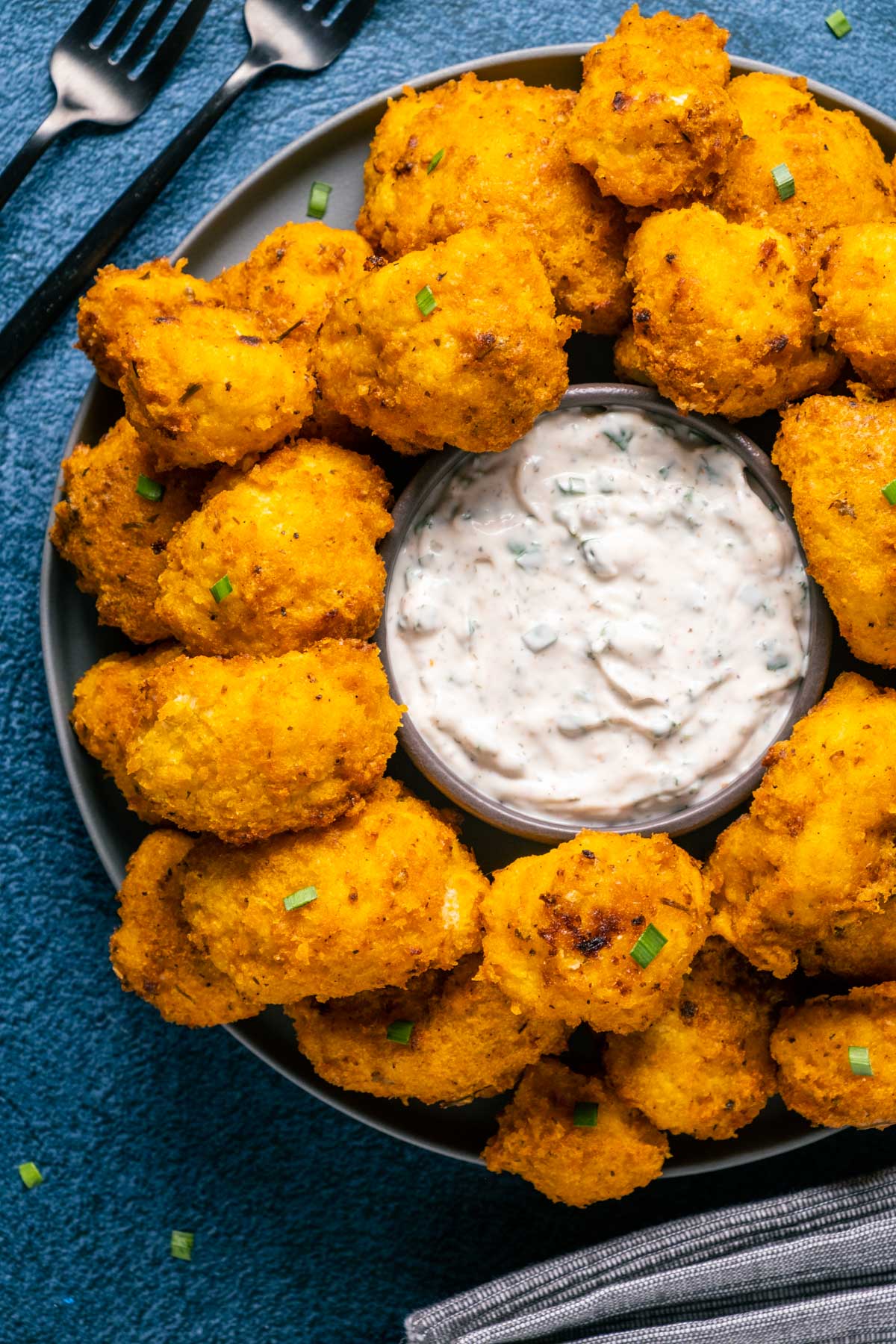 Vegan buffalo cauliflower on a plate with a bowl of ranch dressing. 