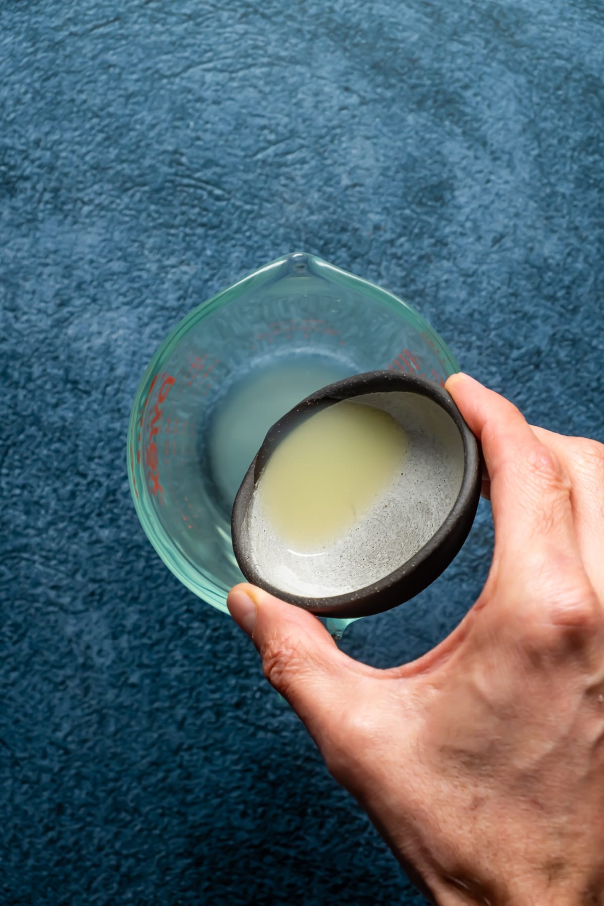Pouring lemon juice into a glass jug.