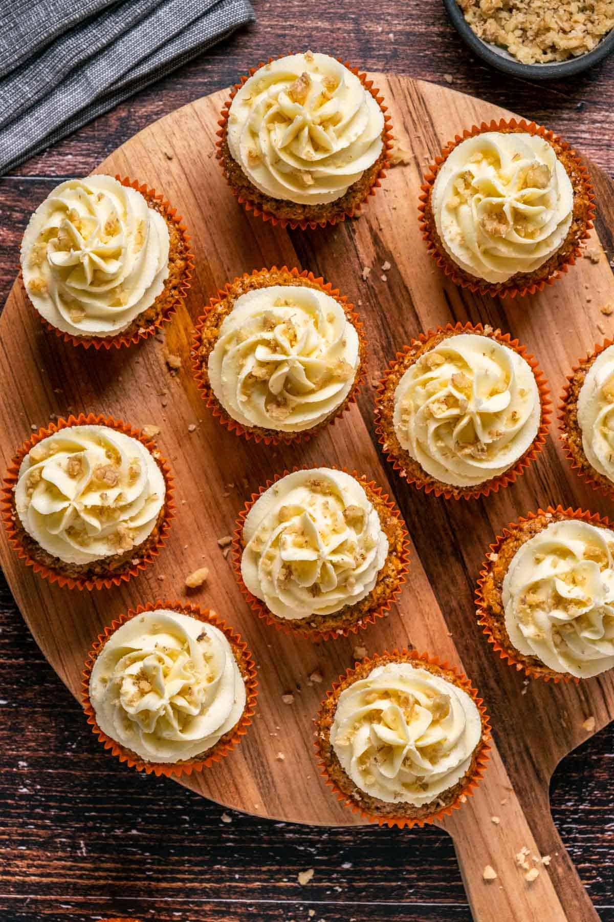 Vegan carrot cake cupcakes on a wooden board. 