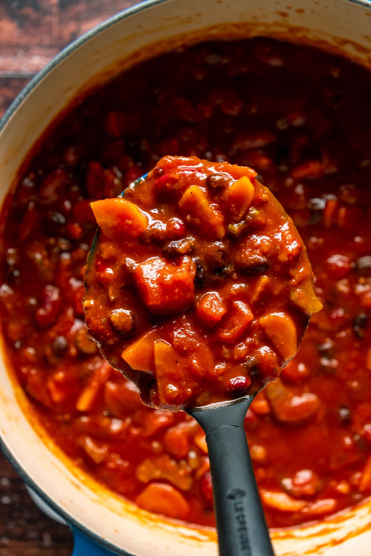 Vegan chili in a pot with a serving spoon.