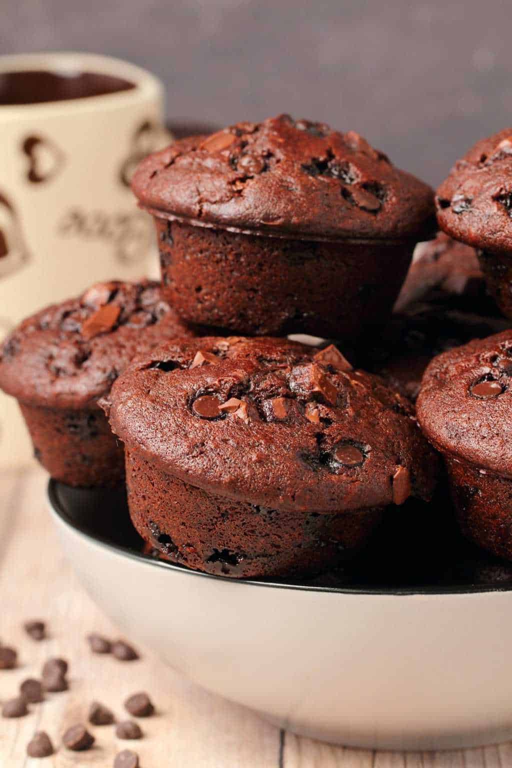 Vegan chocolate muffins stacked up in a stone bowl. 