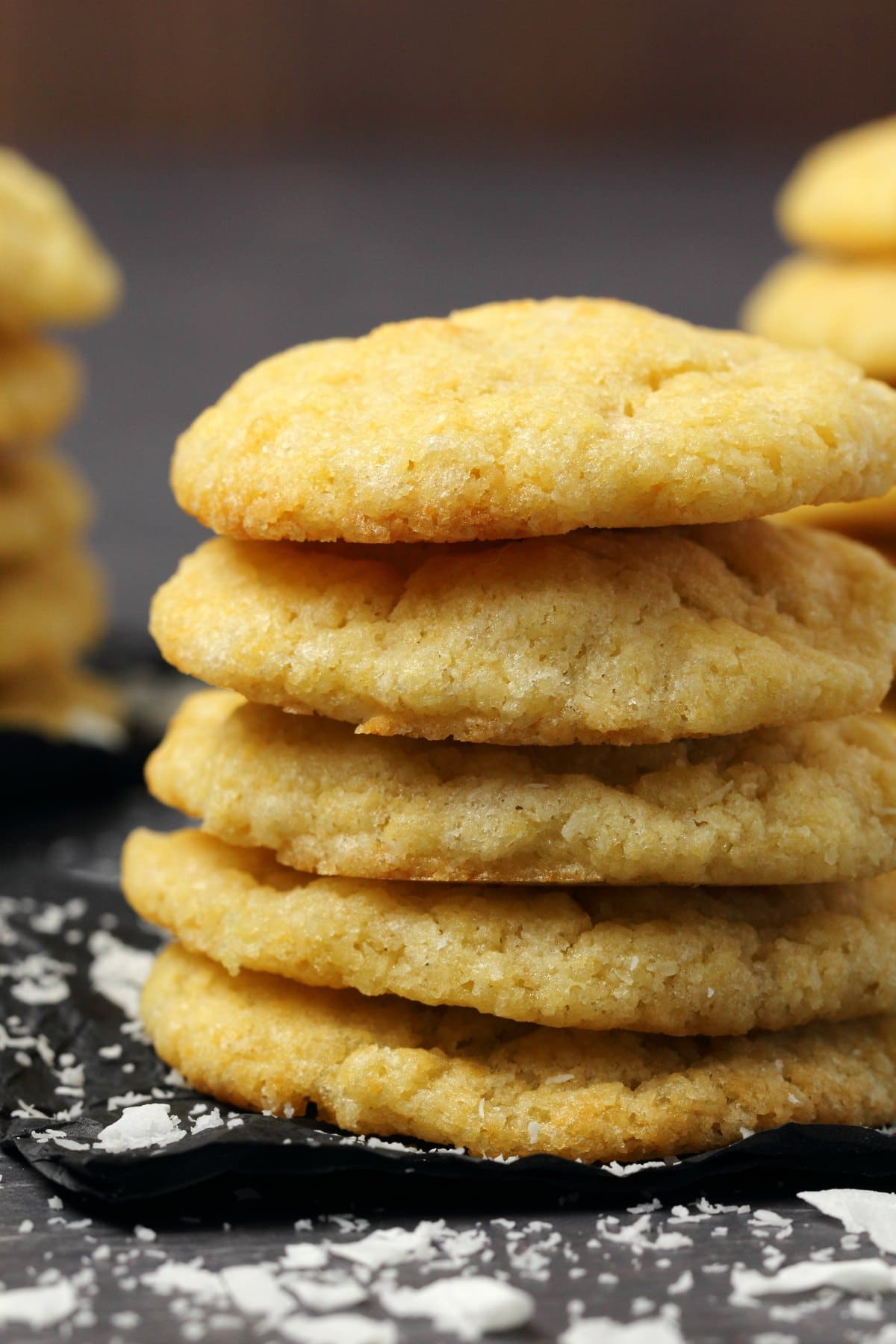 Vegan coconut cookies in a stack on black tissue paper. 