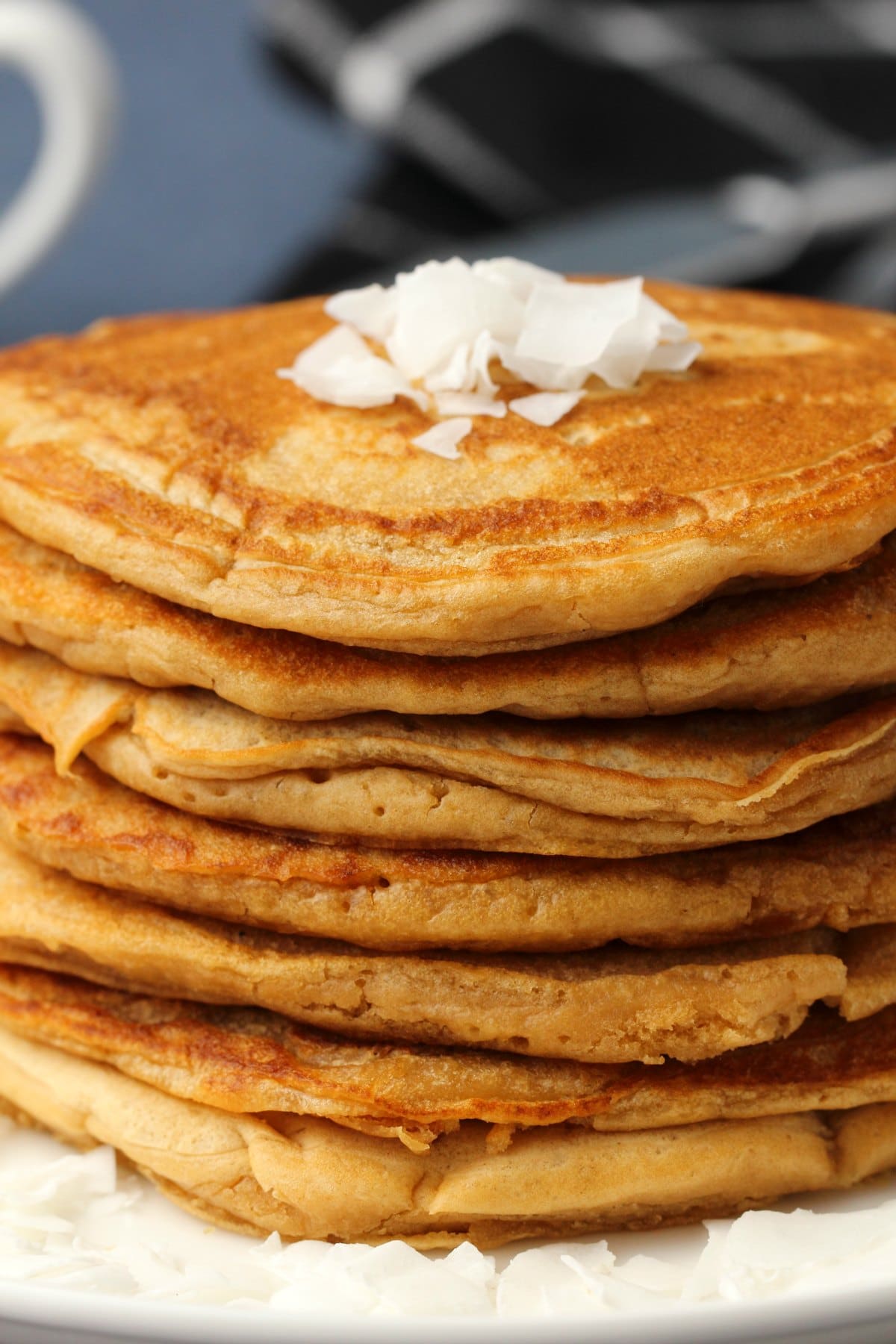 Vegan coconut pancakes in a stack on a white plate. 