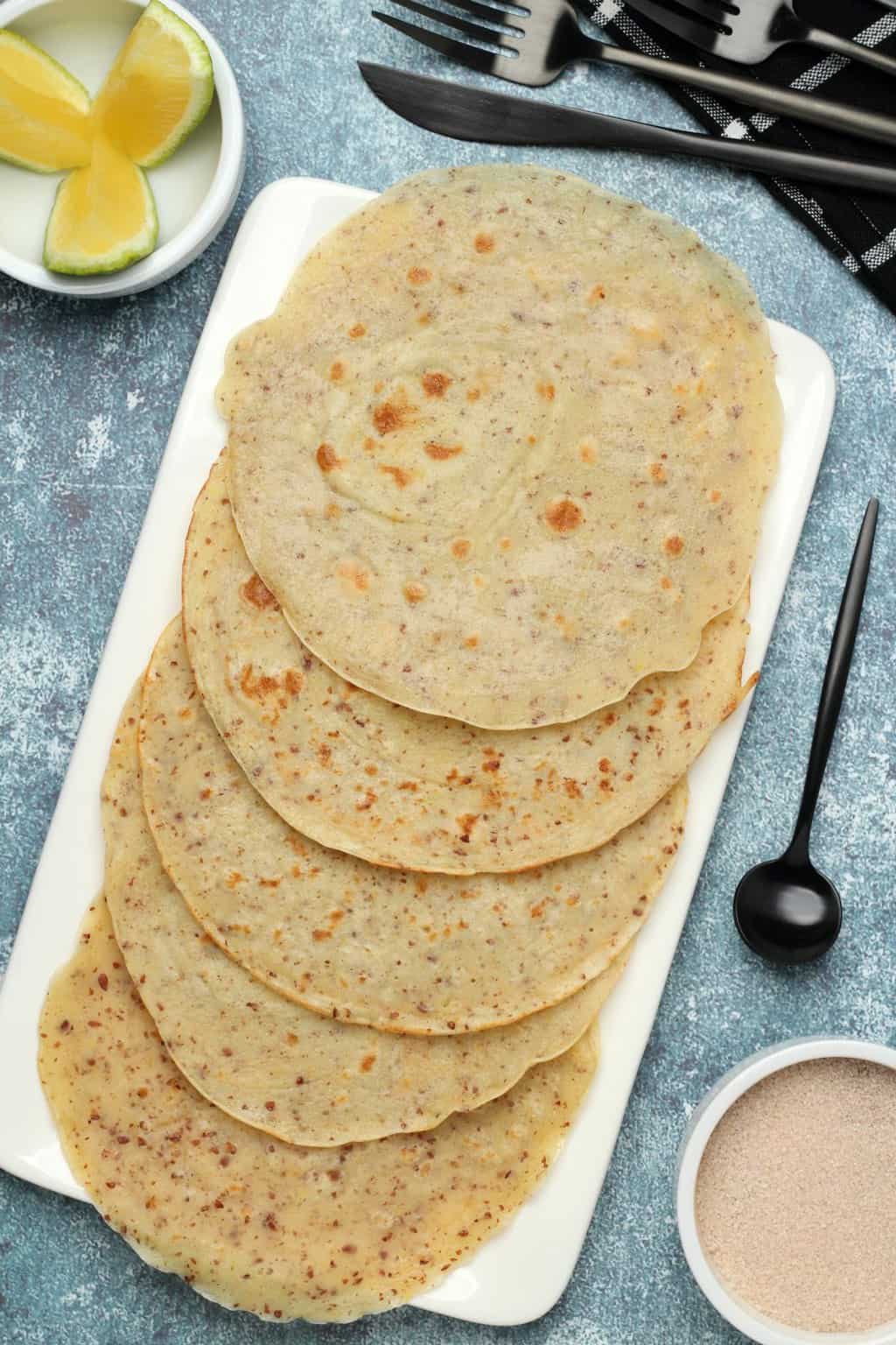 Vegan crepes lined up on a white plate. 