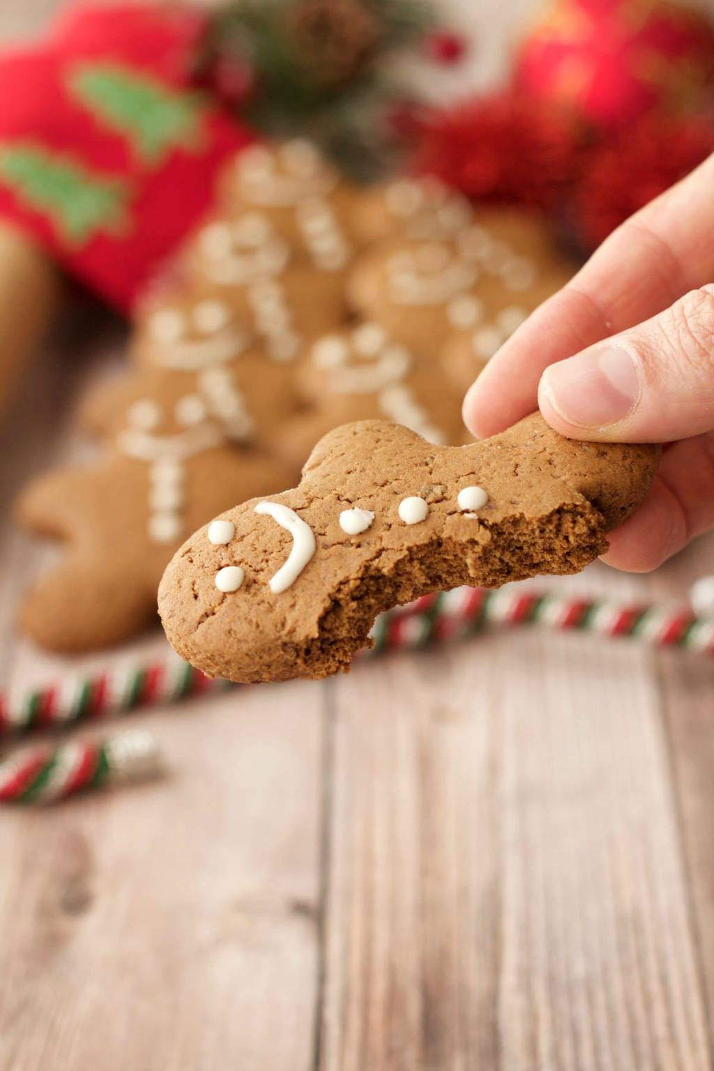 A vegan gingerbread cookie with a bite taken out of it. 