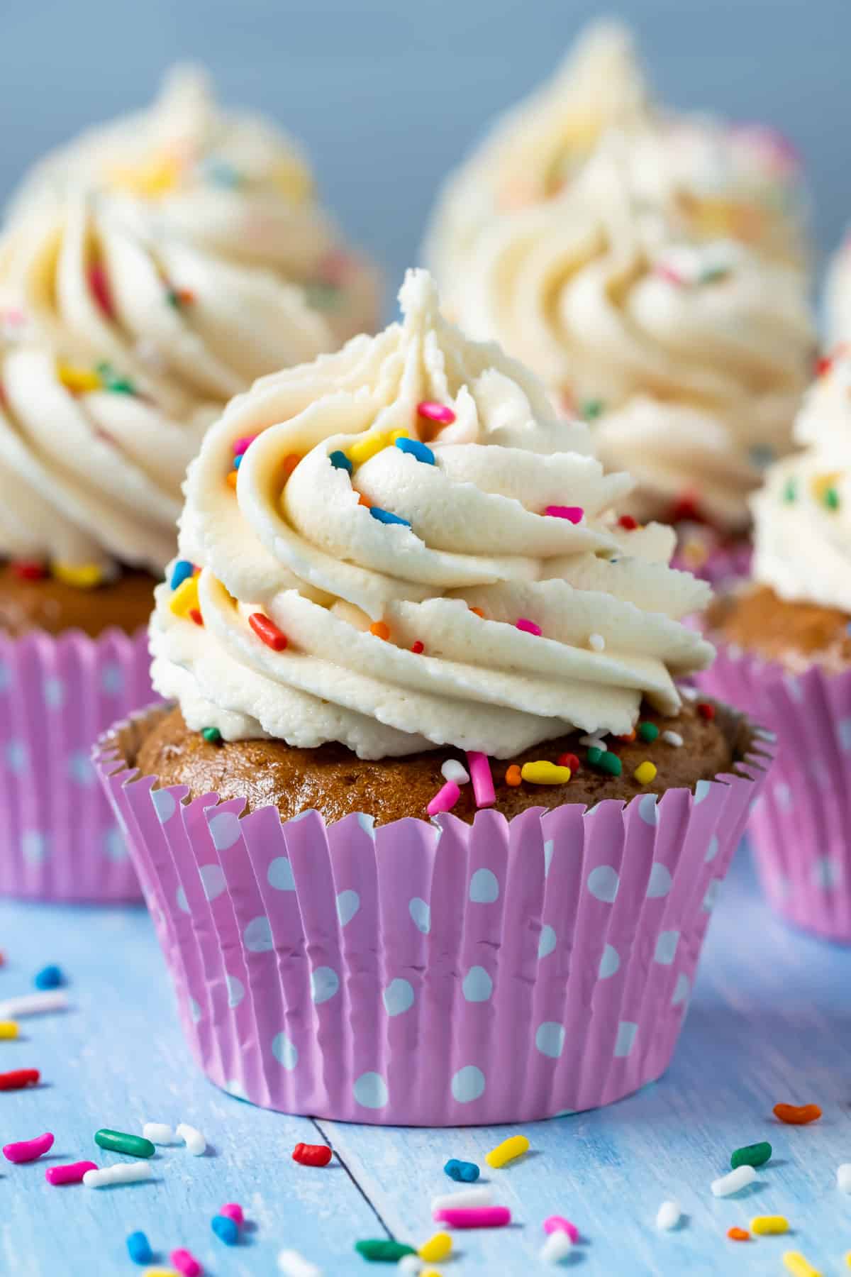 Vegan gluten free vanilla cupcakes topped with frosting and sprinkles.