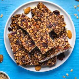 Vegan granola bars stacked up on a white plate.