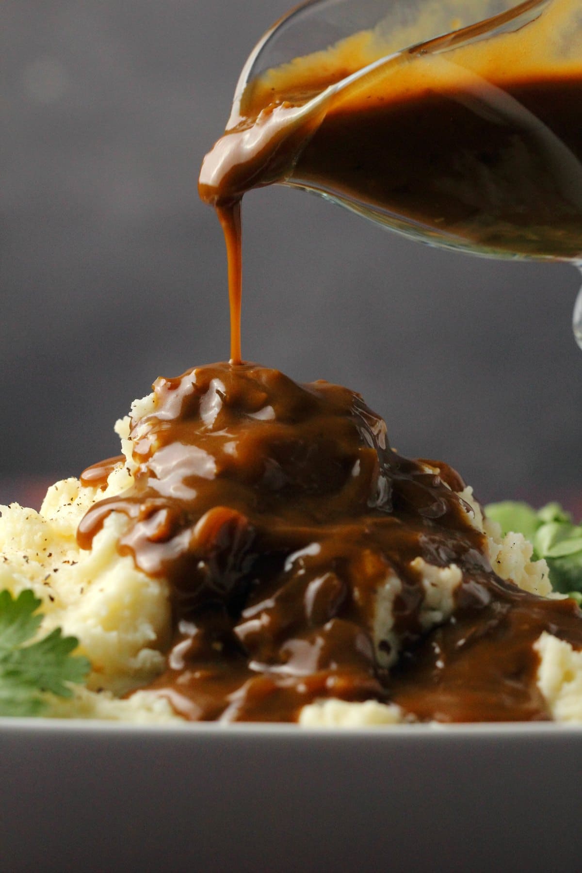 Vegan gravy pouring over mashed potatoes. 