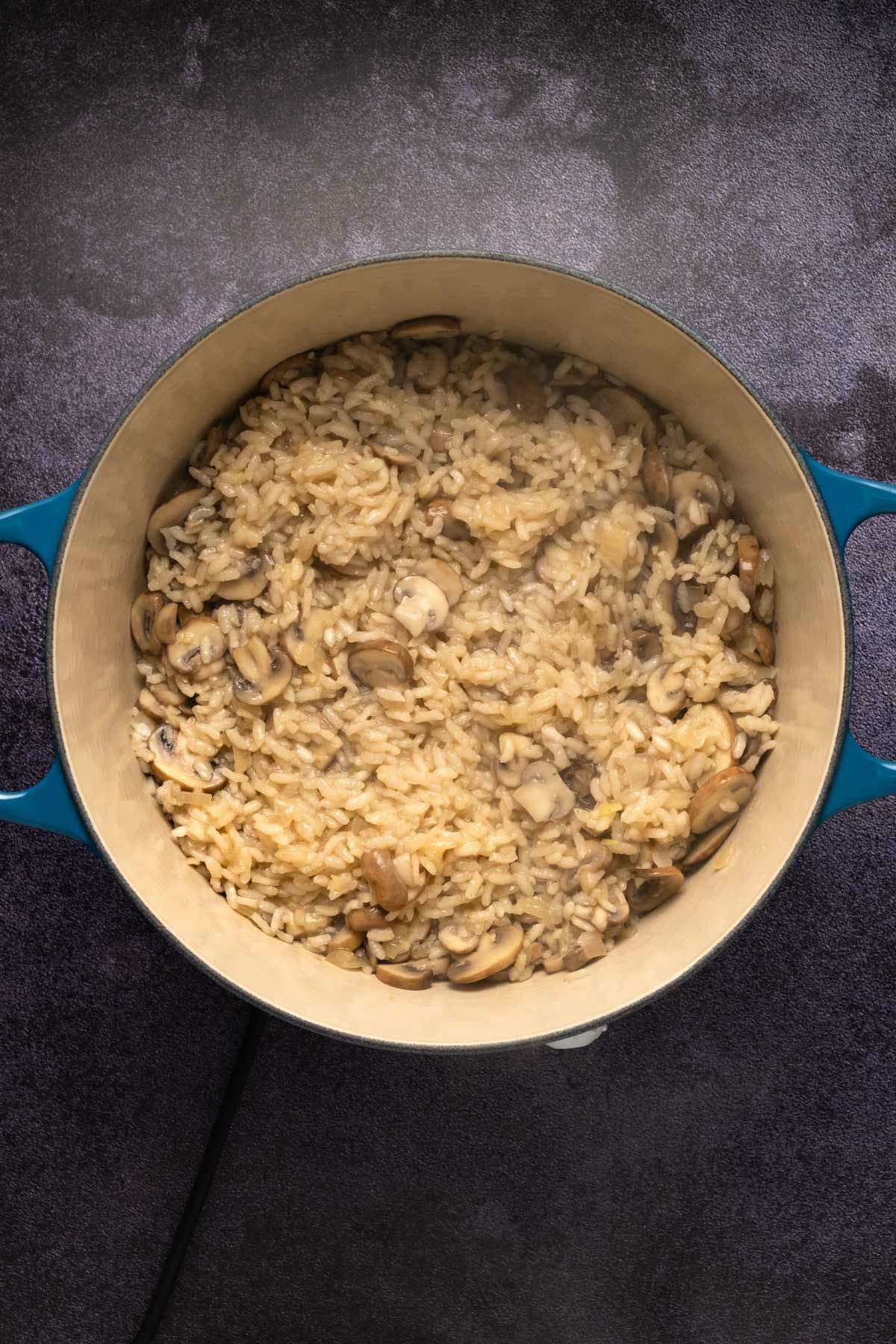 Mushroom risotto cooking in a pot.