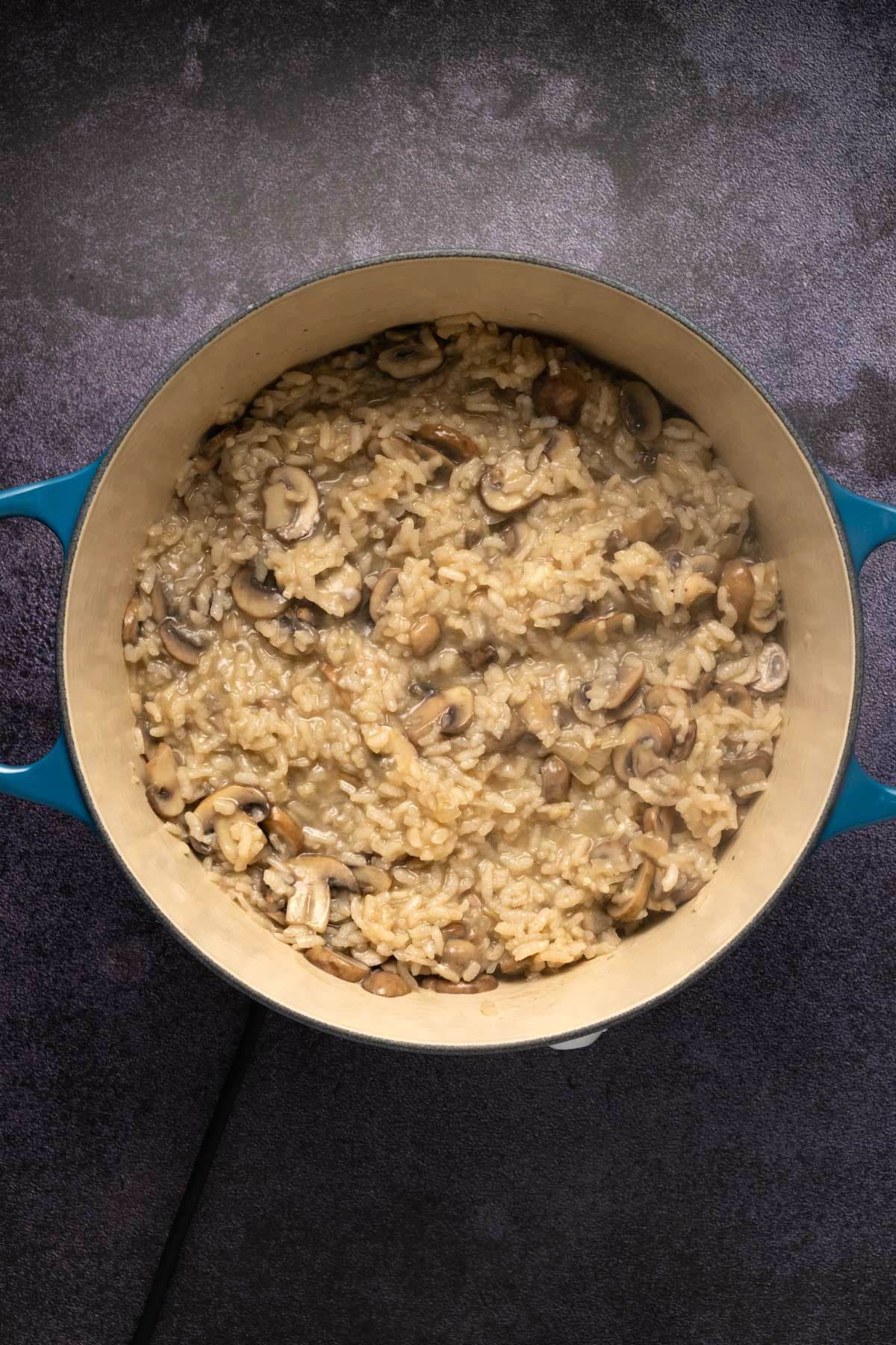 Mushroom risotto cooking in a pot.