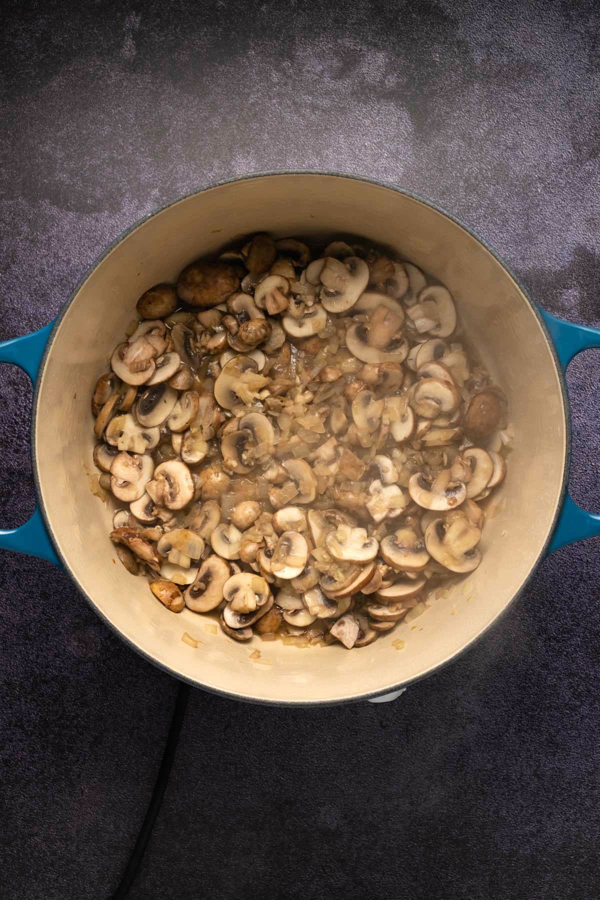 Sautéed mushrooms and onions in a pot.