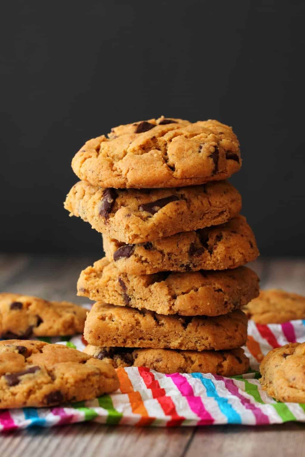 Vegan Peanut Butter Chocolate Chip Cookies in a stack against a dark background. 