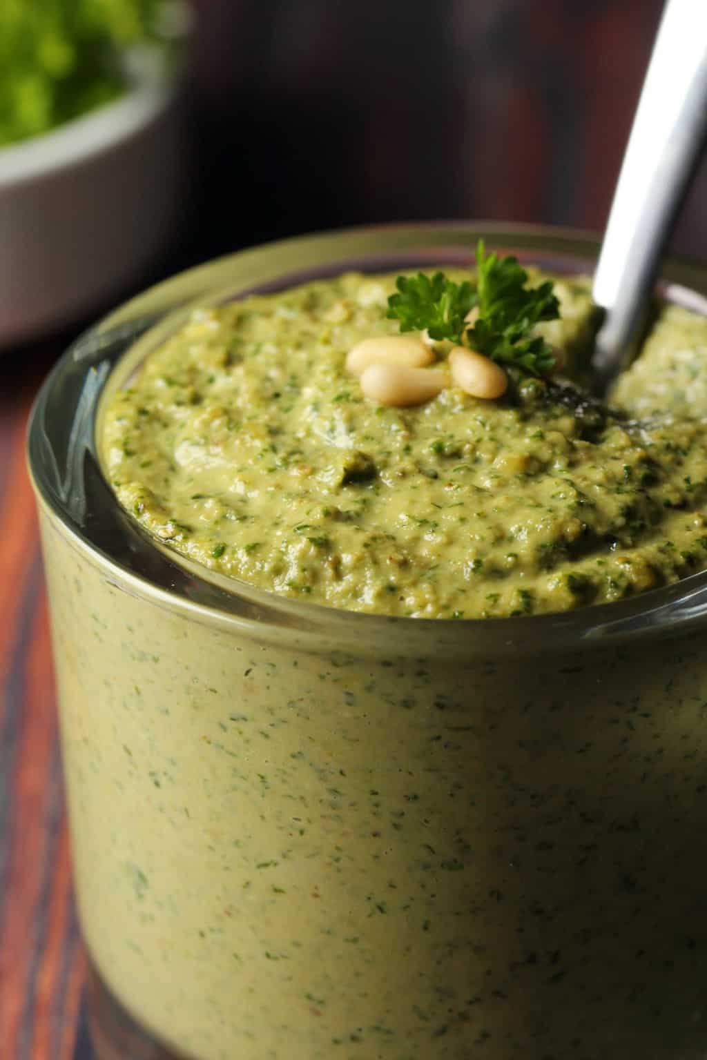 Vegan pesto in a glass jar with a spoon. 