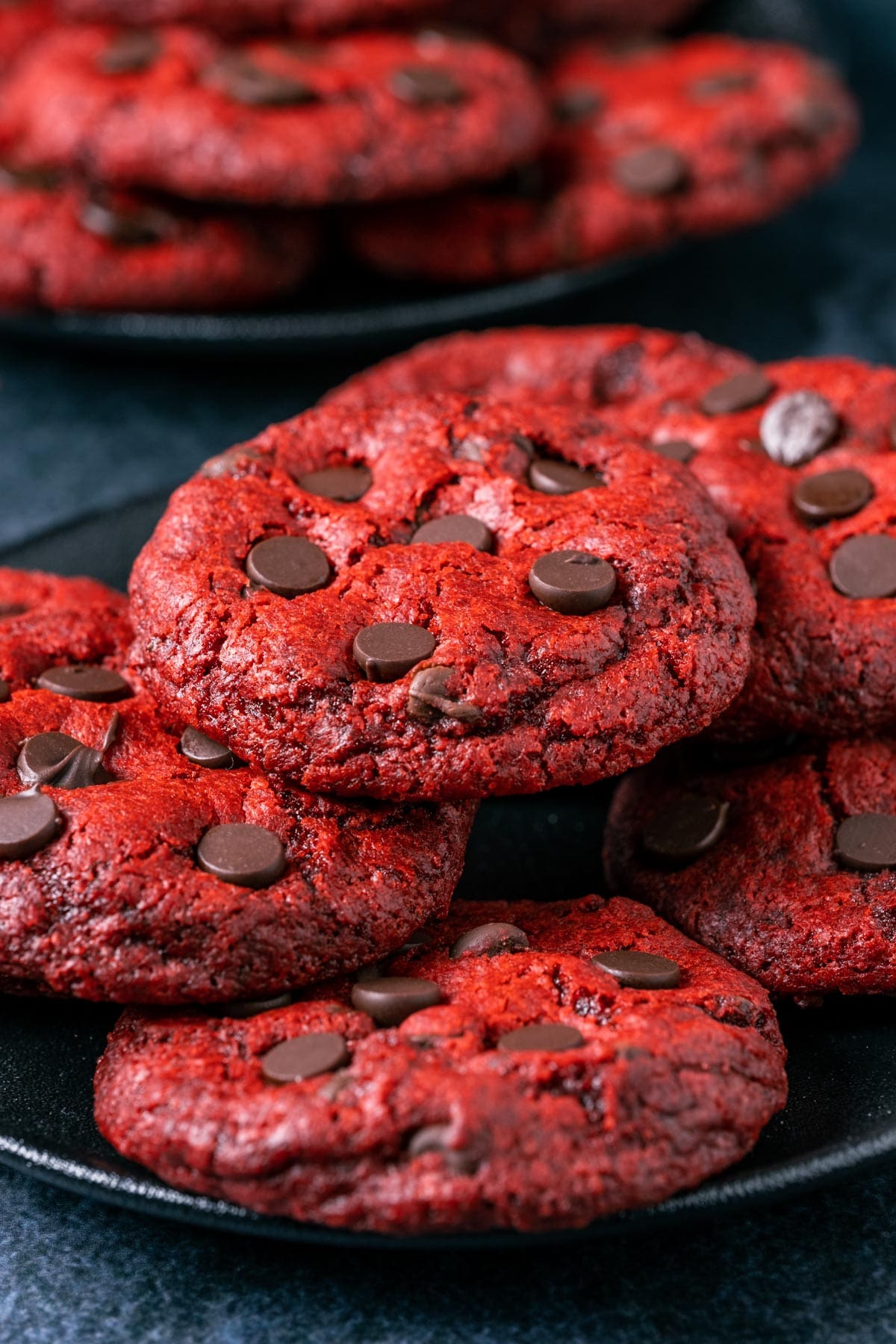 Stack of red velvet cookies on a black plate.