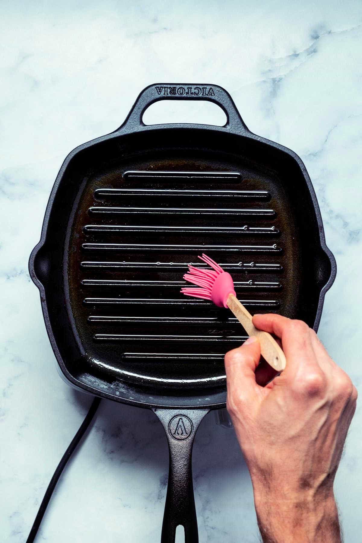 Photo of brushing a grill pan with oil.