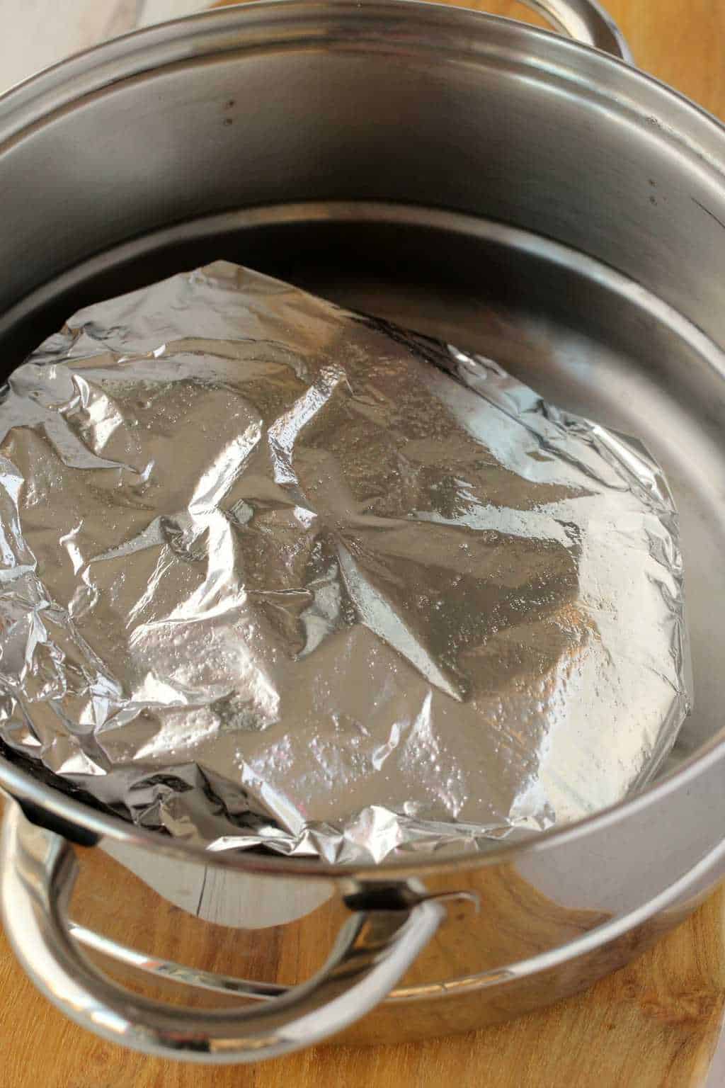Seitan wrapped in tinfoil and steaming in a steamer pot. 