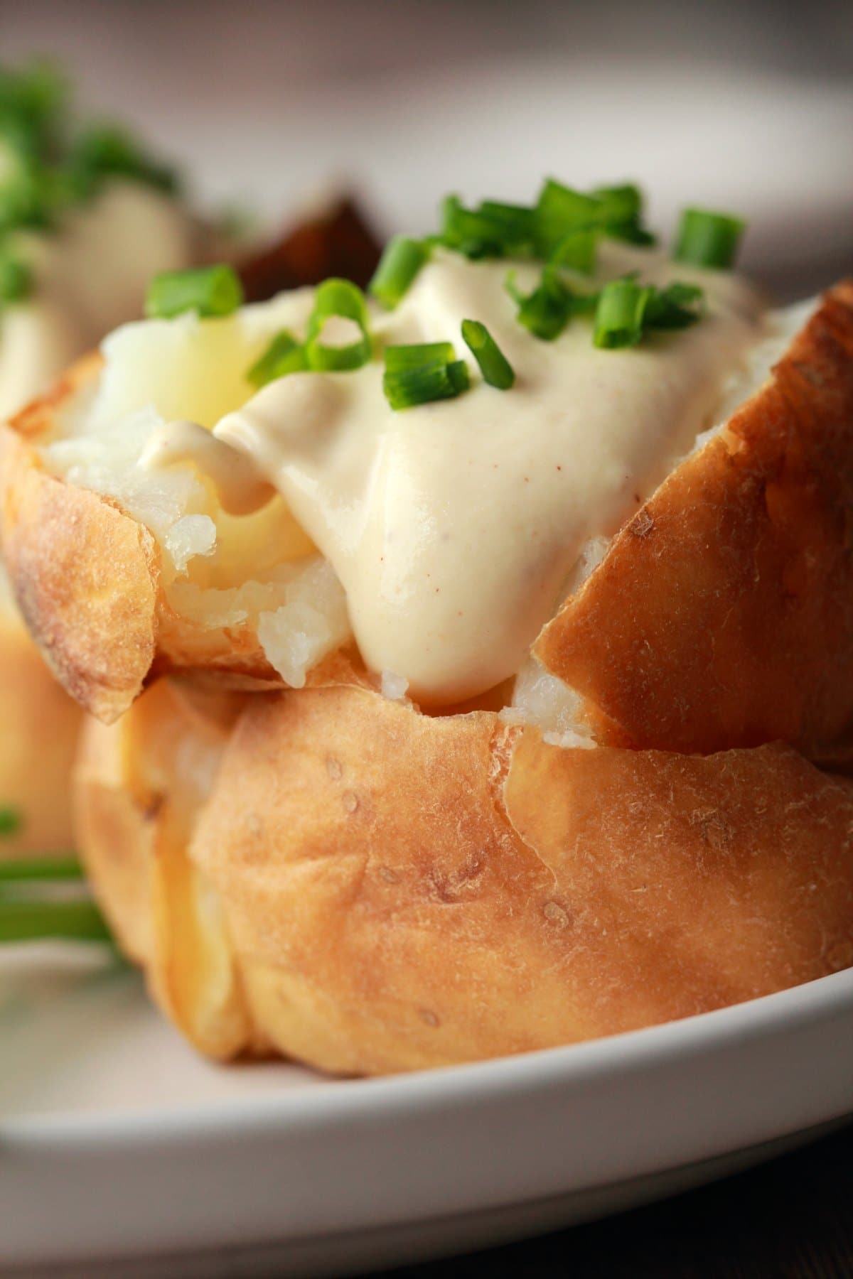 Baked potato topped with sour cream and chives. 