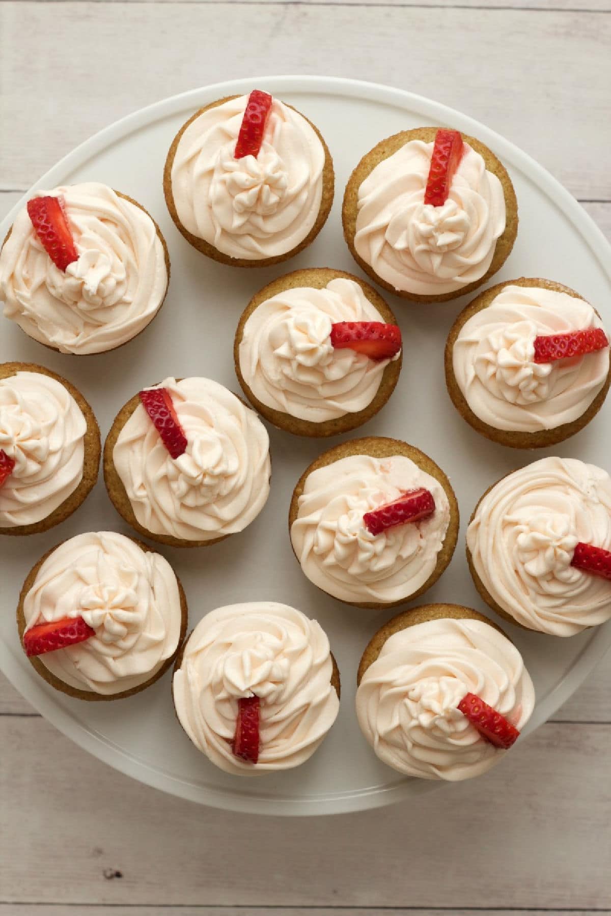 Vegan vanilla cupcakes on a white cake stand. 