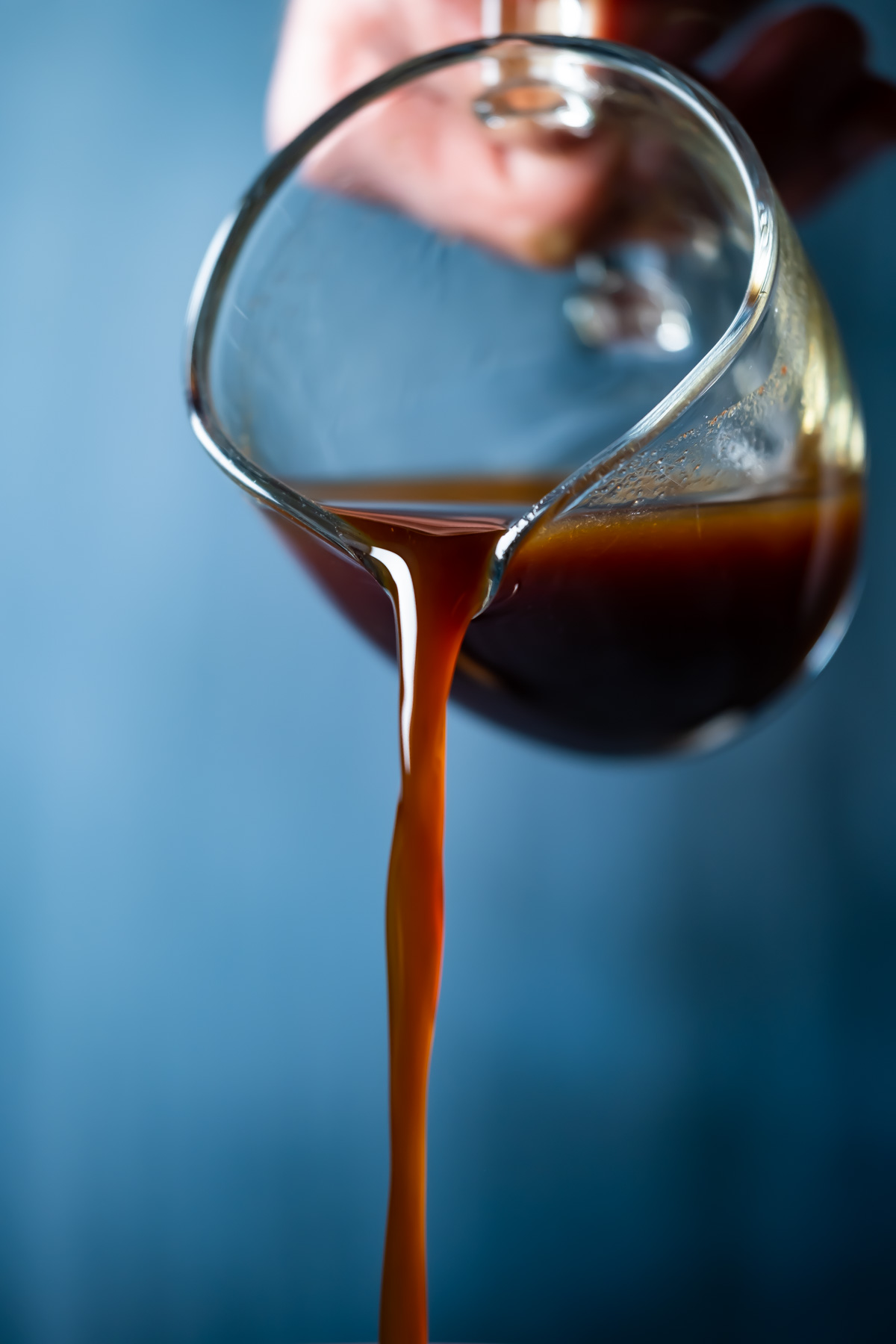 Vegan worcestershire sauce pouring from a glass jug.